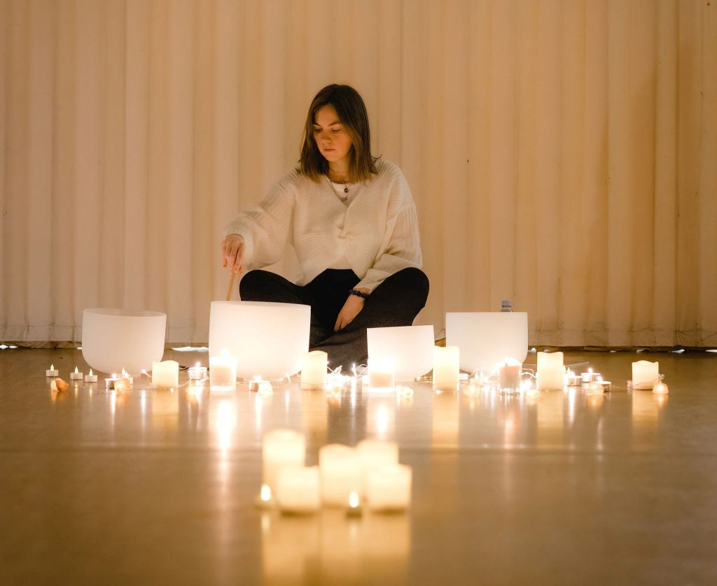 Person surrounded by candles as she lights one