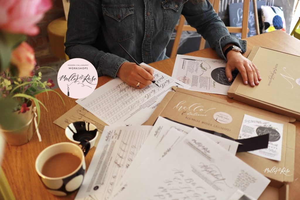 image of white and brown craft paper with person writing in calligraphy.