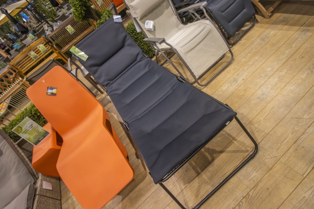 image of a large black sunbed next to an orange sun lounger